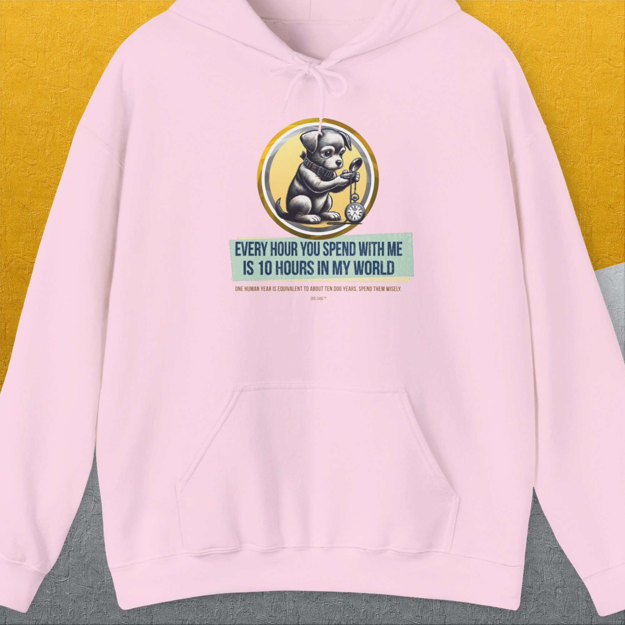 This light pink hoodie, One Human Year = Ten Dog Years, Volume 1, features a cute dog design celebrating time with pets by comparing human and dog years. Designed by Dog Gang.