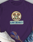 Purple Allright Come And Get It, Volume 4, womens T-shirt with a cartoon puppy holding a ball crafted from soft ringspun cotton. Text: "ALLRIGHT, COME AND GET IT", perfect for any dog lover. Designed by Dog Gang.