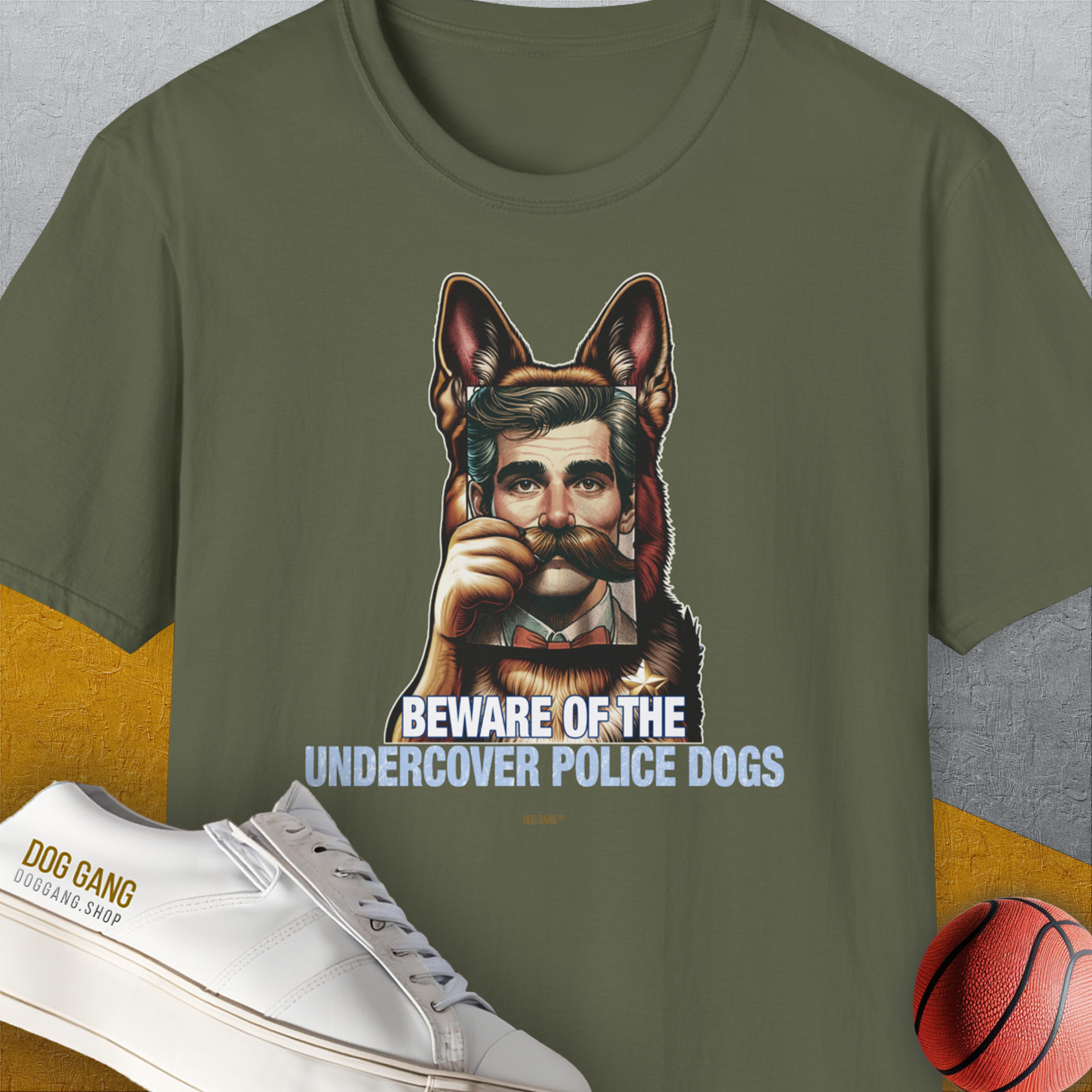 The military green tee showcases a dog disguised as a man with the words BEWARE OF THE UNDERCOVER POLICE DOGS, plus a shoe and basketball. Funny dog design. Designed by Dog Gang.