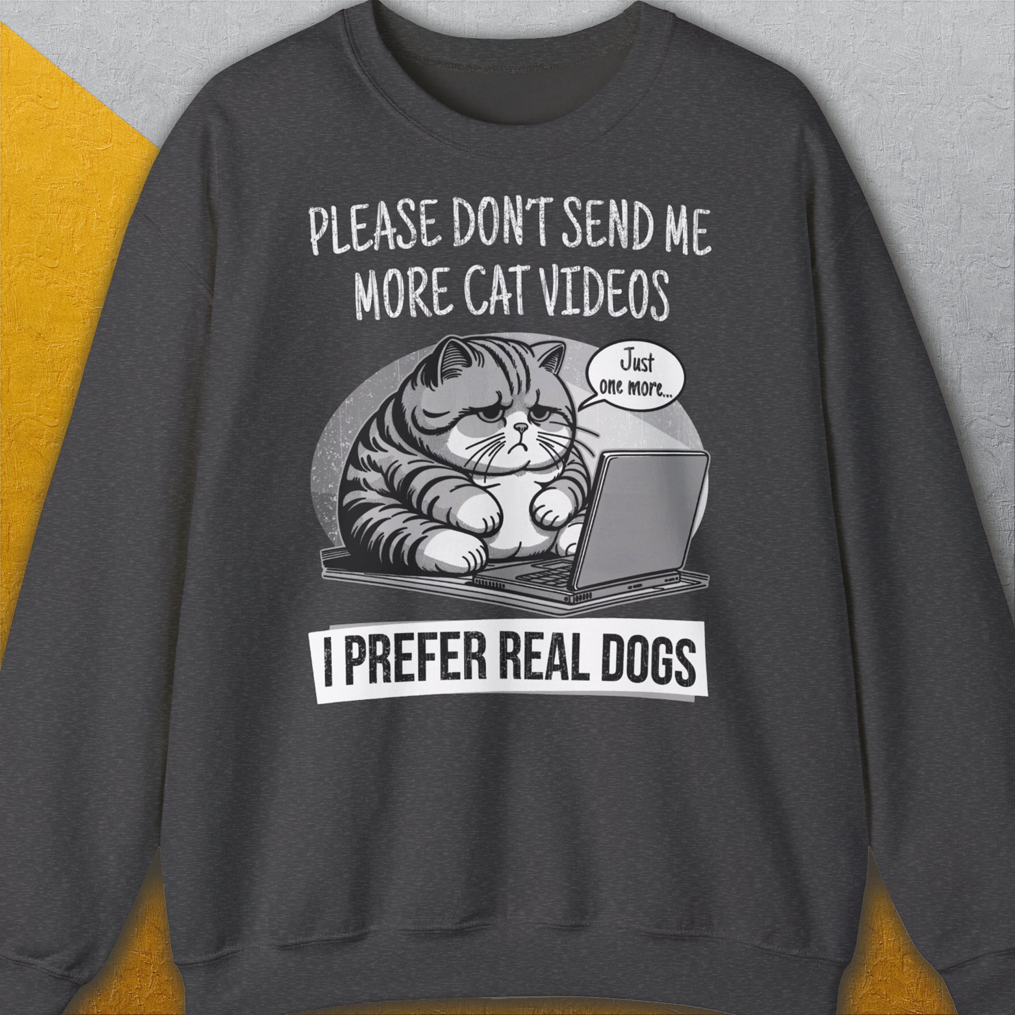 Das Unisex-Sweatshirt „The Cat Videos Series, Volume 1“ in Dark Heather zeigt eine Cartoon-Katze auf einem Laptop mit dem englischsprachigen Text: „Bitte schick mir keine Katzenvideos mehr, ich bevorzuge echte Hunde.“ Design von Dog Gang.