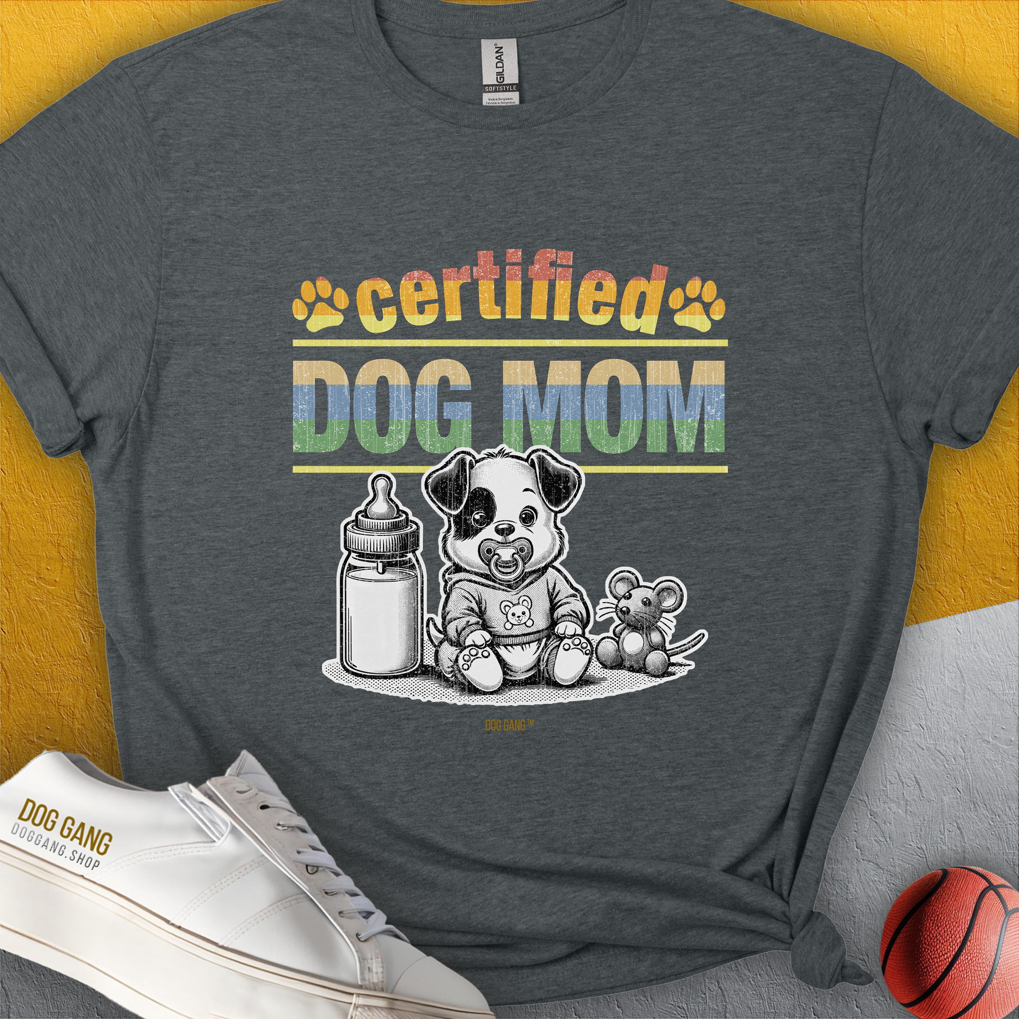 Gray unisex T-shirt featuring a cute puppy with a milk bottle and toy. Perfect dog-themed design for any dog lover. Designed by Dog Gang.