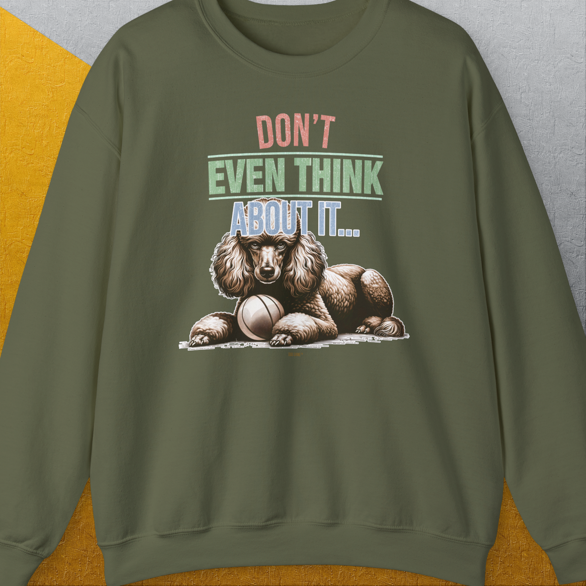 Military green sweatshirt with graphic of a poodle guarding his fetch ball, reading "DONT EVEN THINK ABOUT IT". Perfect for any dog lover, blending humor with style. Designed by Dog Gang.