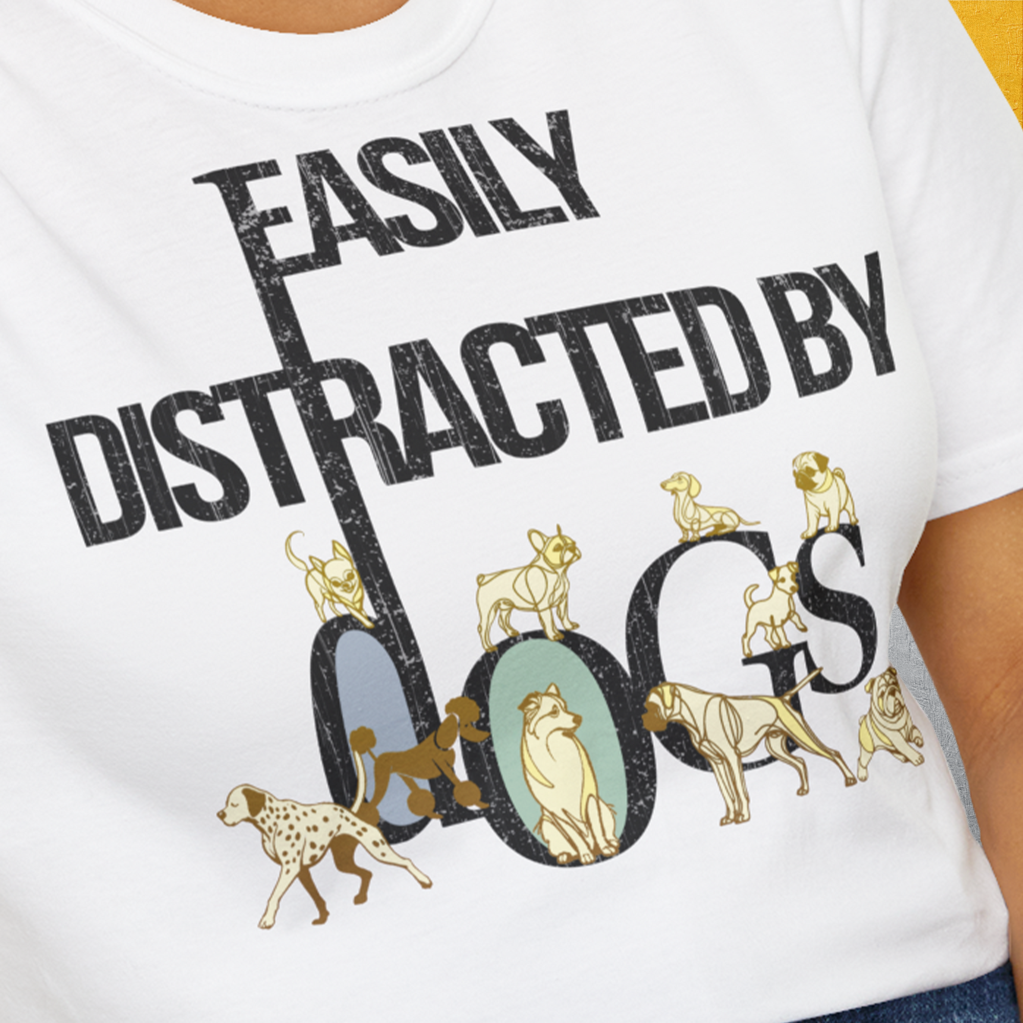Close-up of a white unisex T-shirt, Easily Distracted By Dogs Series, Volume 1, featuring bold black letters and dog illustrations perfect for any dog lover. Designed by Dog Gang.