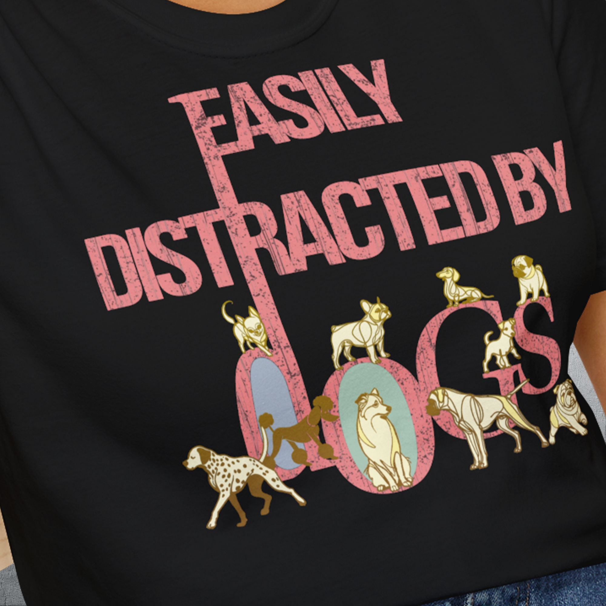 This black, soft-style 100% cotton unisex T-shirt from the Easily Distracted By Dogs Series, Volume 2 features a dog-themed design with playful pink and golden text. The illustrations include a Dalmatian, Golden Retriever, a pug, a Poodle, a Bulldog, Husky and more. Designed by Dog Gang.