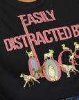 This black, soft-style 100% cotton unisex T-shirt from the Easily Distracted By Dogs Series, Volume 2 features a dog-themed design with playful pink and golden text. The illustrations include a Dalmatian, Golden Retriever, a pug, a Poodle, a Bulldog, Husky and more. Designed by Dog Gang.