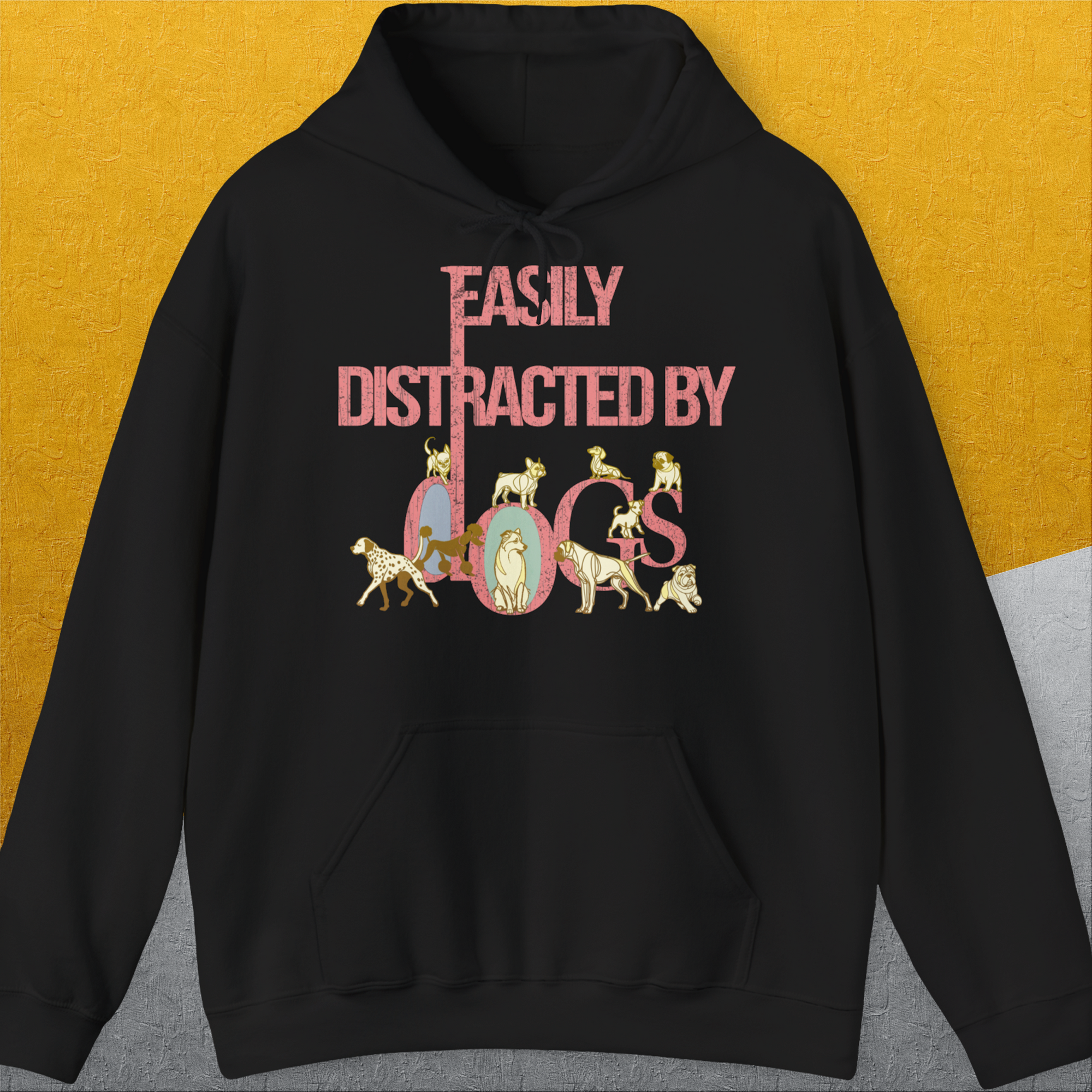 The black hoodie features playful dog illustrations with the saying Easily Distracted By Dogs. A perfect funny shirt for any dog lover. Designed by Dog Gang.