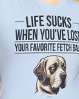 Eine Person trägt das Unisex-T-Shirt „Life Sucks When Youve Lost Your Favorite Fetch Ball, Volume 1“ aus weichem, 100 % Baumwolle mit einer traurigen Hundeillustration.