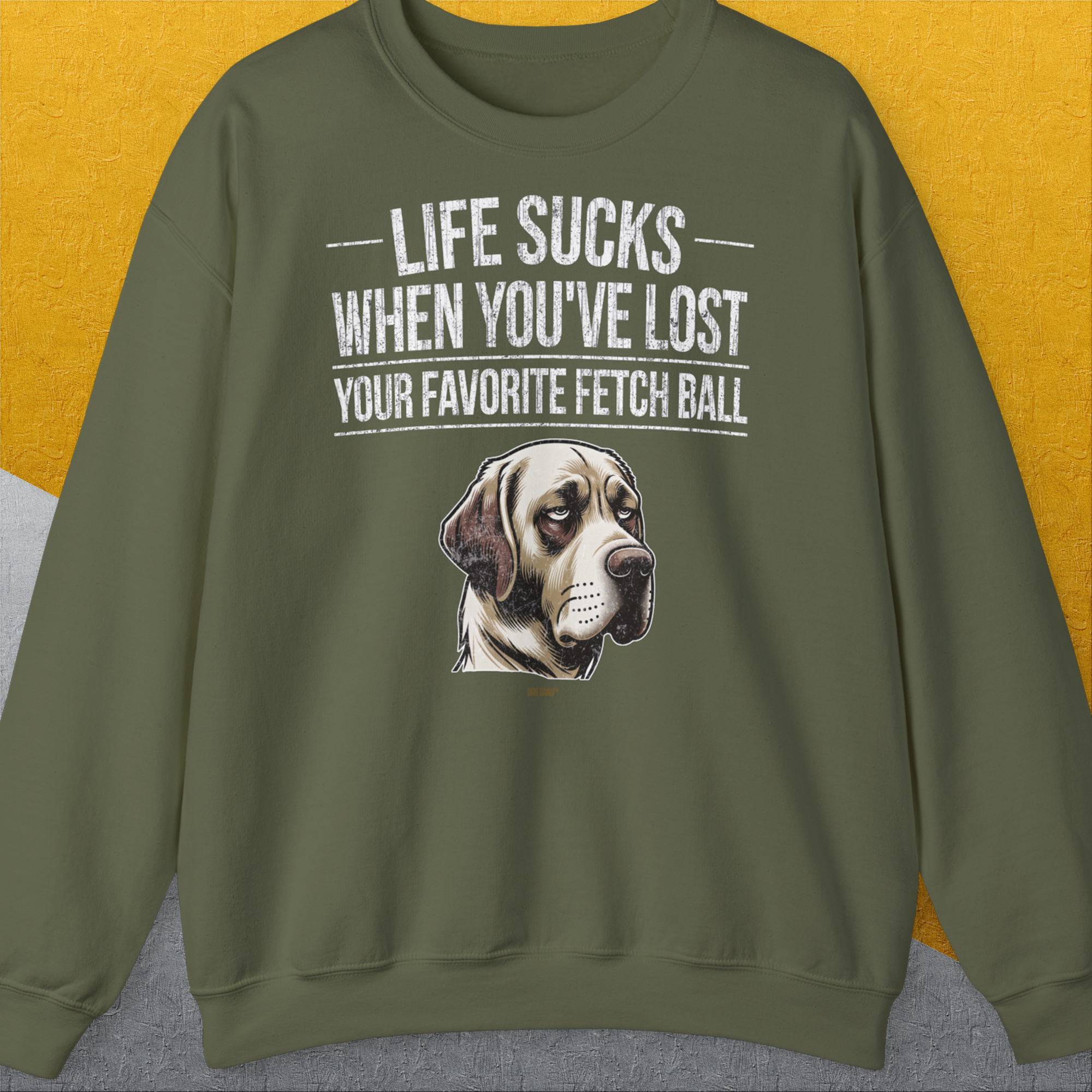 „Life Sucks When Youve Lost Your Favorite Fetch Ball“ zeigt ein lustig gezeichnetes, aber enttäuschtes Hundegesicht (Labrador Retriever). Zur Erinnerung an die Momente, wo dein Hund seinen Lieblingsball bei Spielen verloren hat. Design von Dog Gang.