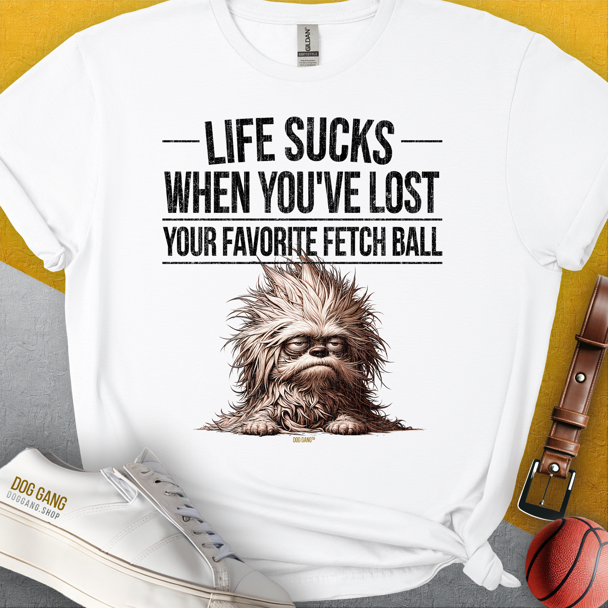Das weiche Unisex-T-Shirt in Weiß zeigt eine zottelige Hundegrafik mit dem Text „Life Sucks When You've Lost Your Favorite Fetch Ball. Aus 100 % Baumwolle. Design von Dog Gang.