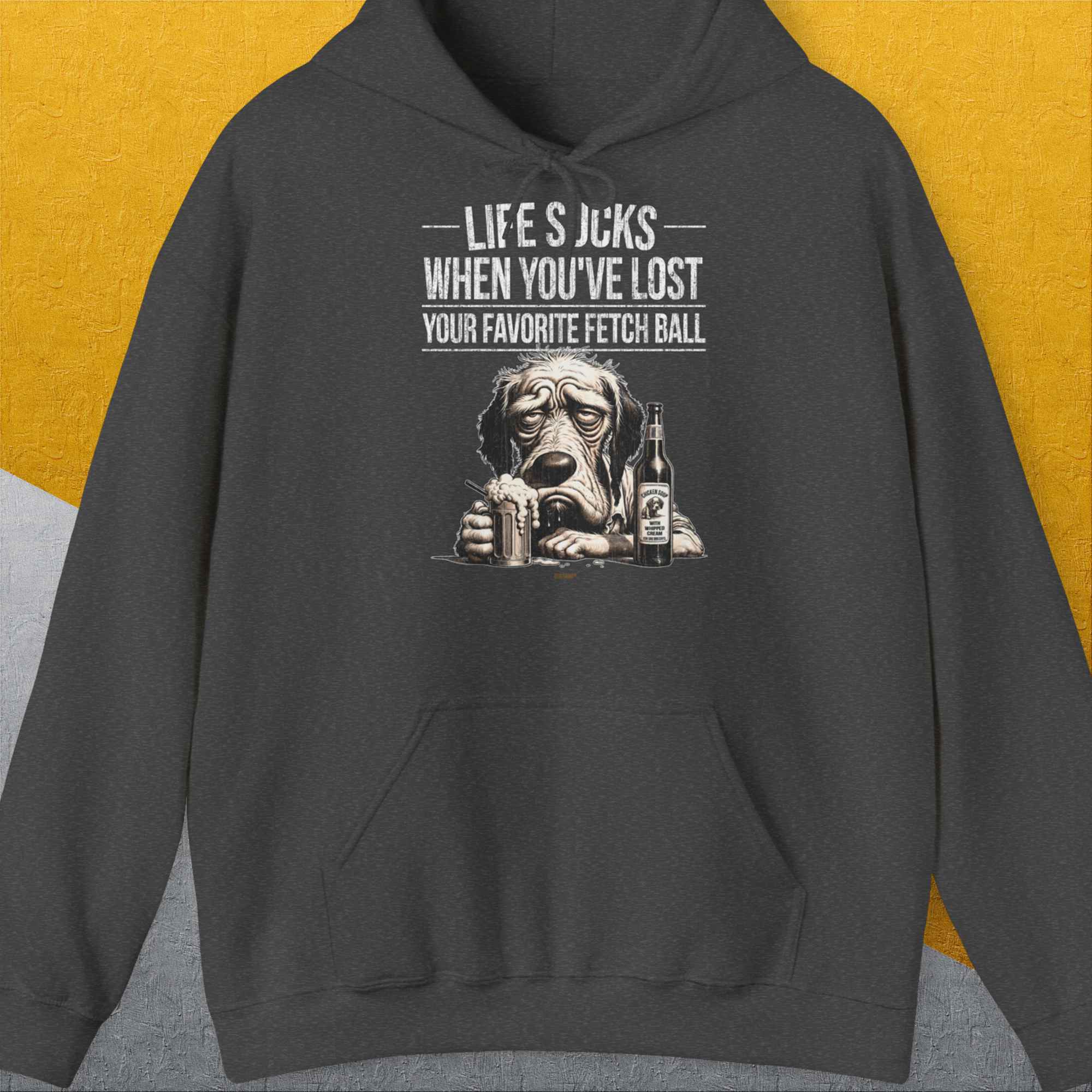 Der lustige Hoodie „Life Sucks When Youve Lost Your Favorite Fetch Ball" zeigt einen traurigen Hund, der eine Flasch hält (Flaschentikett: "Chicken Soup with whipped cream, for sad dog days") und um seinen verlorenen Apportierball trauert. Shirt-Design von Dog Gang.