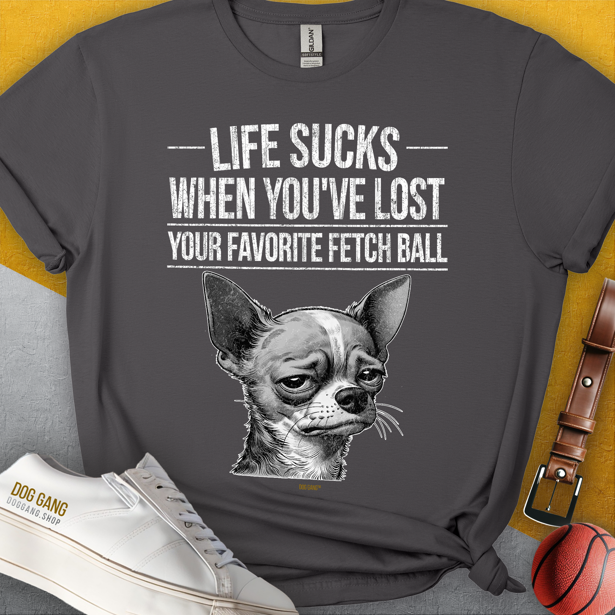 Lustiges Unisex-T-Shirt mit einem witzig gezeichnetem traurigen Hundegesicht (Chihuahua) und dem Text „Life Sucks When You've Lost Your Favorite Fetch Ball“. Design von Dog Gang.