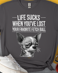 Lustiges Unisex-T-Shirt mit einem witzig gezeichnetem traurigen Hundegesicht (Chihuahua) und dem Text „Life Sucks When You've Lost Your Favorite Fetch Ball“. Design von Dog Gang.