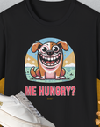 The Me Hungry? Volume 3, Unisex T-Shirt in black features a cute cartoon dog with the phrase ME HUNGRY? next to bone-shaped cookies. Perfect for the dog lover with a sense of humor. Designed by Dog Gang.