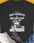 Womens black t-shirt made from ringspun cotton features a funny dog illustration with the saying My dog is easily distracted by cats and stuff. Designed by Dog Gang.