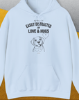 Light blue unisex hoodie with a cute dog design and the quote: My dog is easily distracted by love & hugs. Designed by Dog Gang.