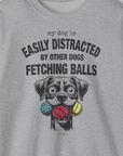 A unisex crewneck sweatshirt features a dog-themed design with the quote My Dog Is Easily Distracted By Other Dogs Fetching Balls, on ethically grown cotton. Designed by Dog Gang.