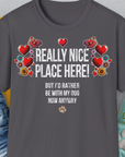 Anthrazitfarbenes Unisex-T-Shirt aus weicher Baumwolle mit Herz- und Blumenmuster. Darauf steht auf englisch: „Wirklich schöner Ort hier! Aber ich wäre jetzt sowieso lieber bei meinem Hund.“ Design von Dog Gang.