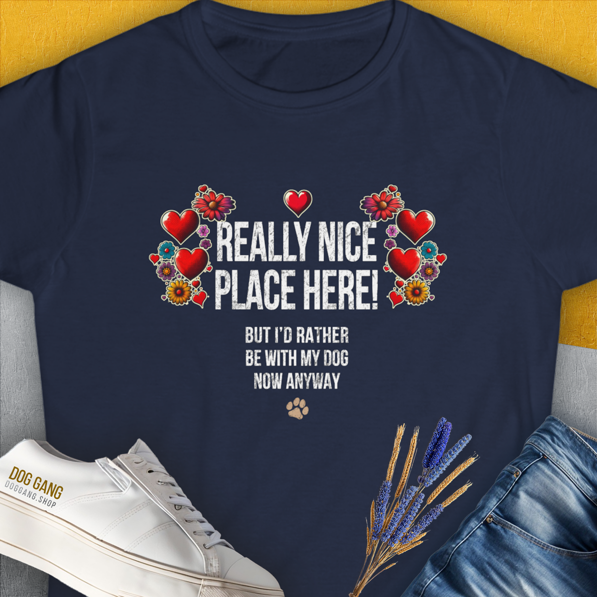 The Really Nice Place Here, Womens T-Shirt features a cute dog design intertwined with floral and heart elements. Text reads "Really nice place here! But I’d rather be with my dog now anyway." Designed by Dog Gang.