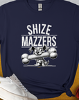 Discover the Shize Mazzers, Volume 1 t-shirt in navy blue, featuring a funny cartoon dog holding an oversized bone in its mouth, preventing it from speaking properly. The text reads "SHIZE MAZZERS". Perfect for any dog lover. Designed by Dog Gang.