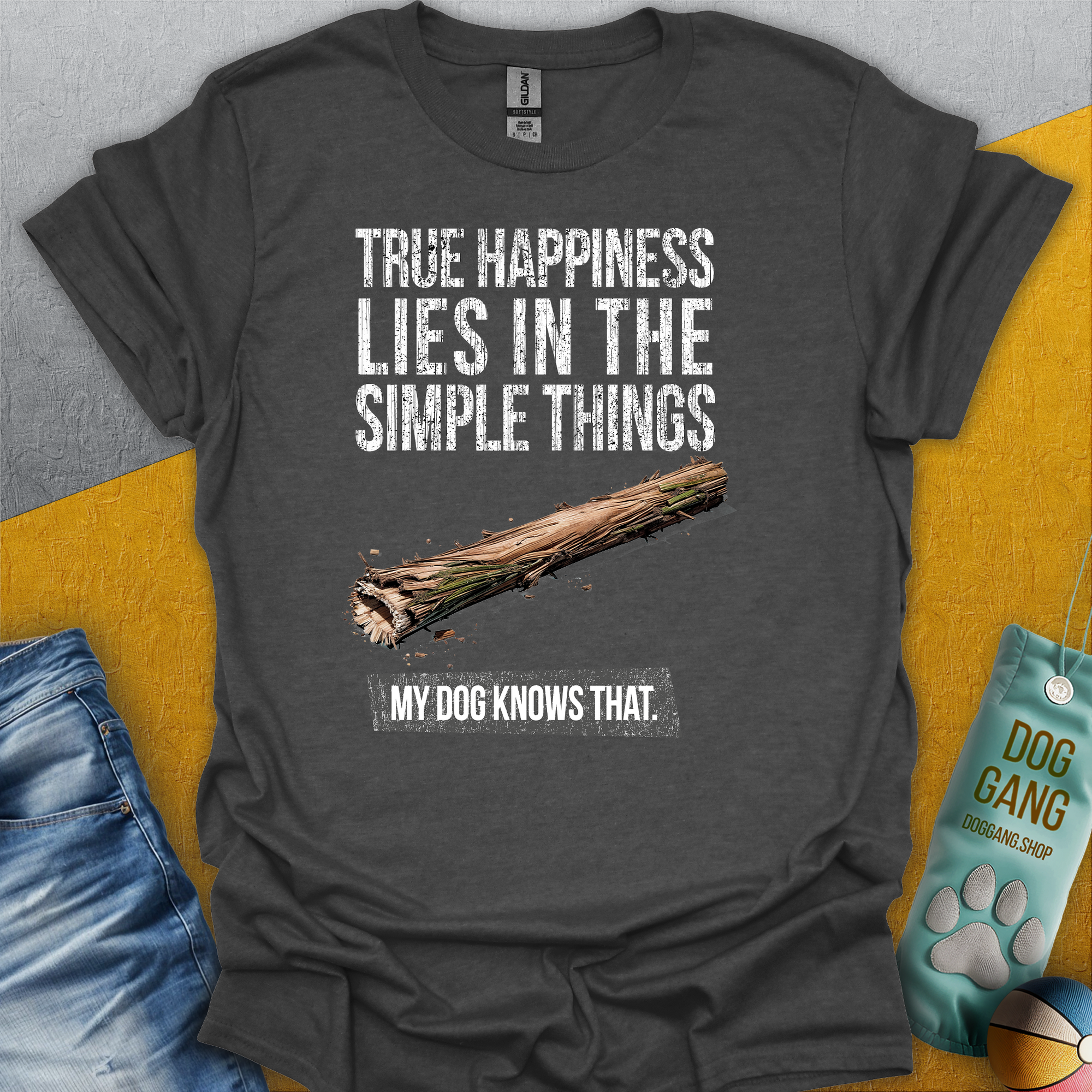 Das Unisex-T-Shirt „True Happiness Series One, Volume 2“ in Dark Heather zeigt eine Strichgrafik von einem einfachen Holzstock und den Spruch „True happiness lies in the simple things - my dog knows that“ Design von Dog Gang.