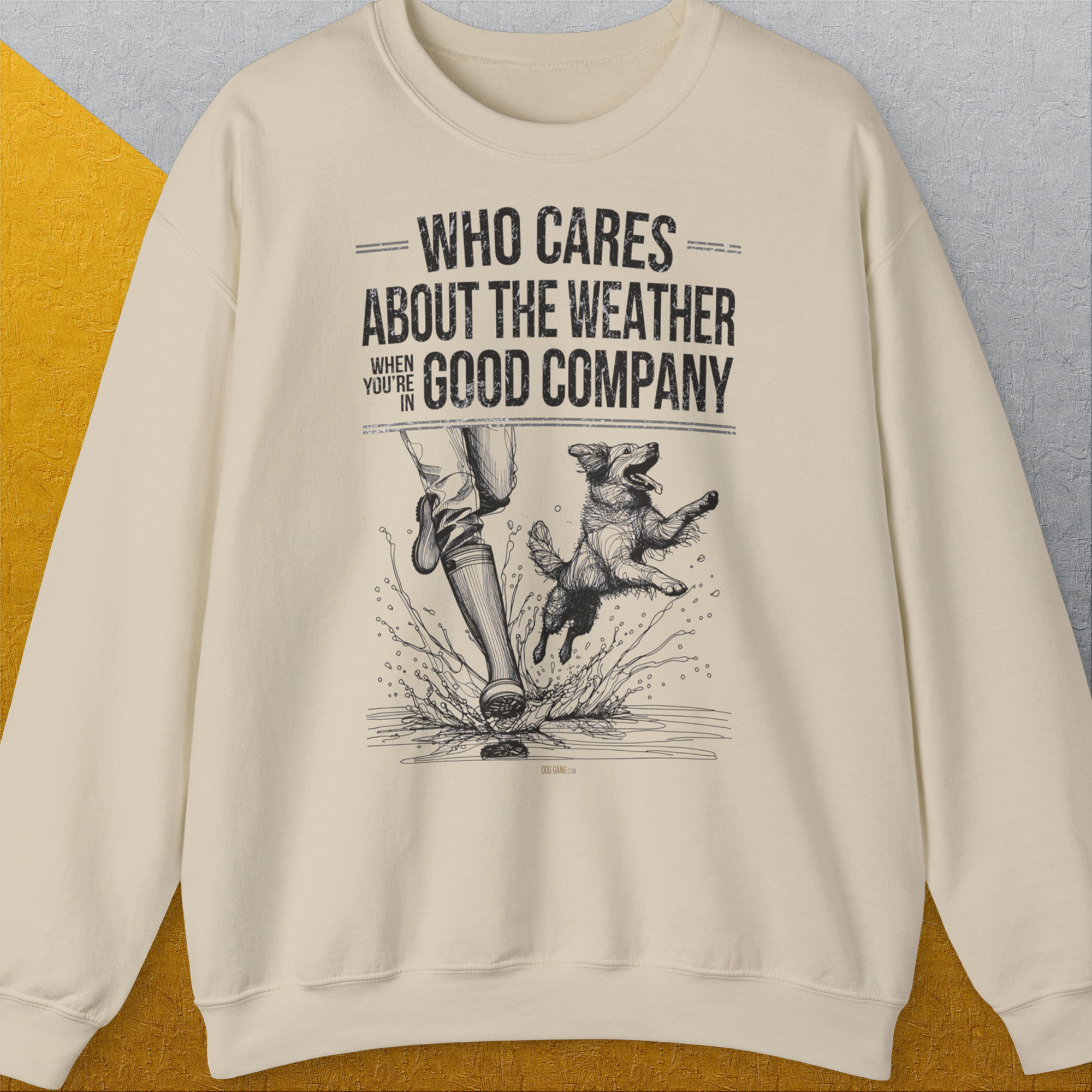 Das Unisex-Sweatshirt „Who Cares About The Weather When Youre In Good Company, Volume 1“ mit einer Illustration einer Person und eines Hundes beim Planschen durch Wassepfützen im Regen. Design von Dog Gang.
