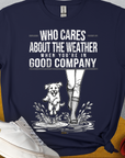 Das Unisex-T-Shirt „Who Cares About The Weather When You're In Good Company?", Volume 2“ zeigt eine verspielte Grafik einer Person und eines Hundes im Regen. Aus 100 % Baumwolle. Design von Dog Gang.