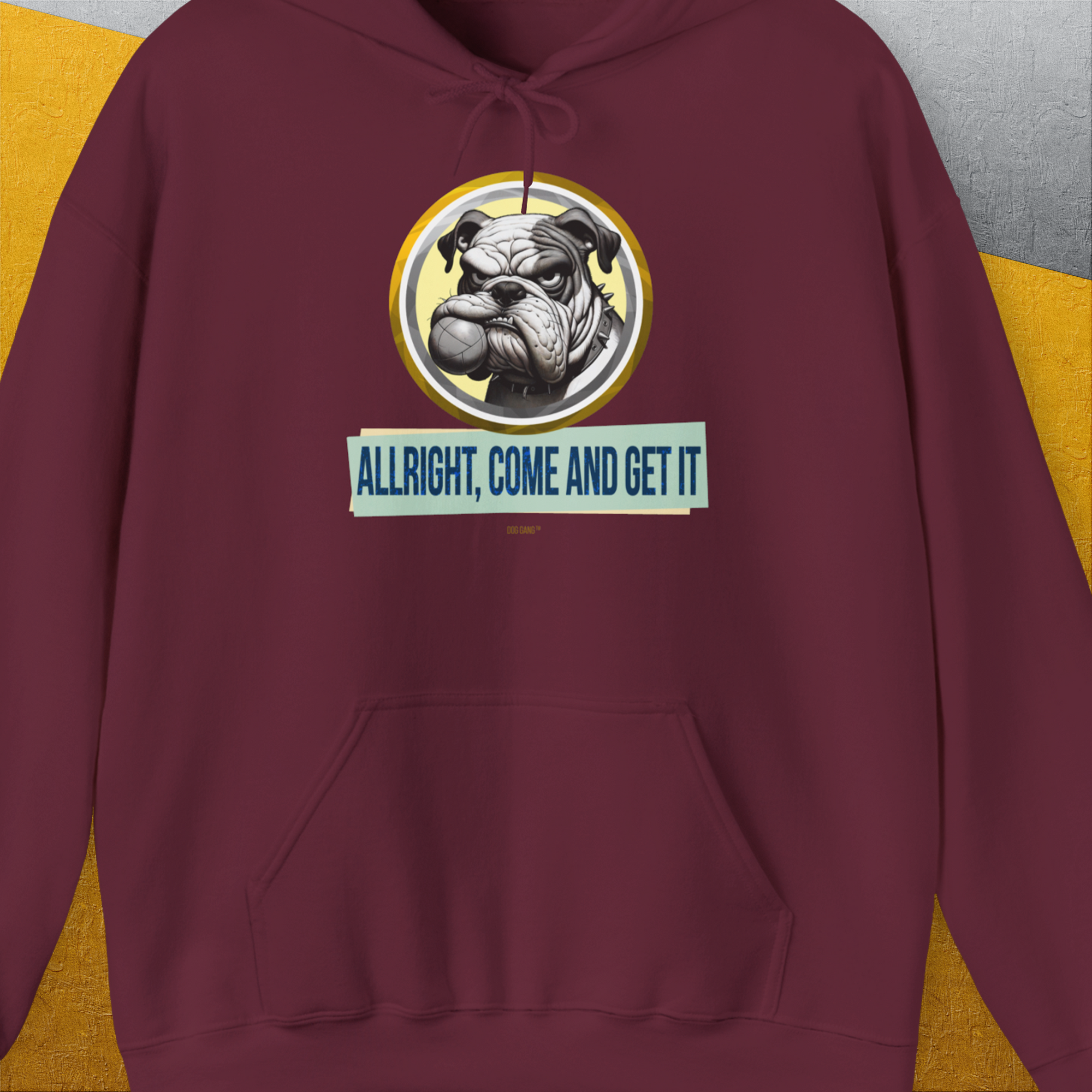 The maroon hoodie showcases a funny dog design with a playful bulldog and the text “ALLRIGHT, COME AND GET IT” boldly displayed. Designed by Dog Gang.