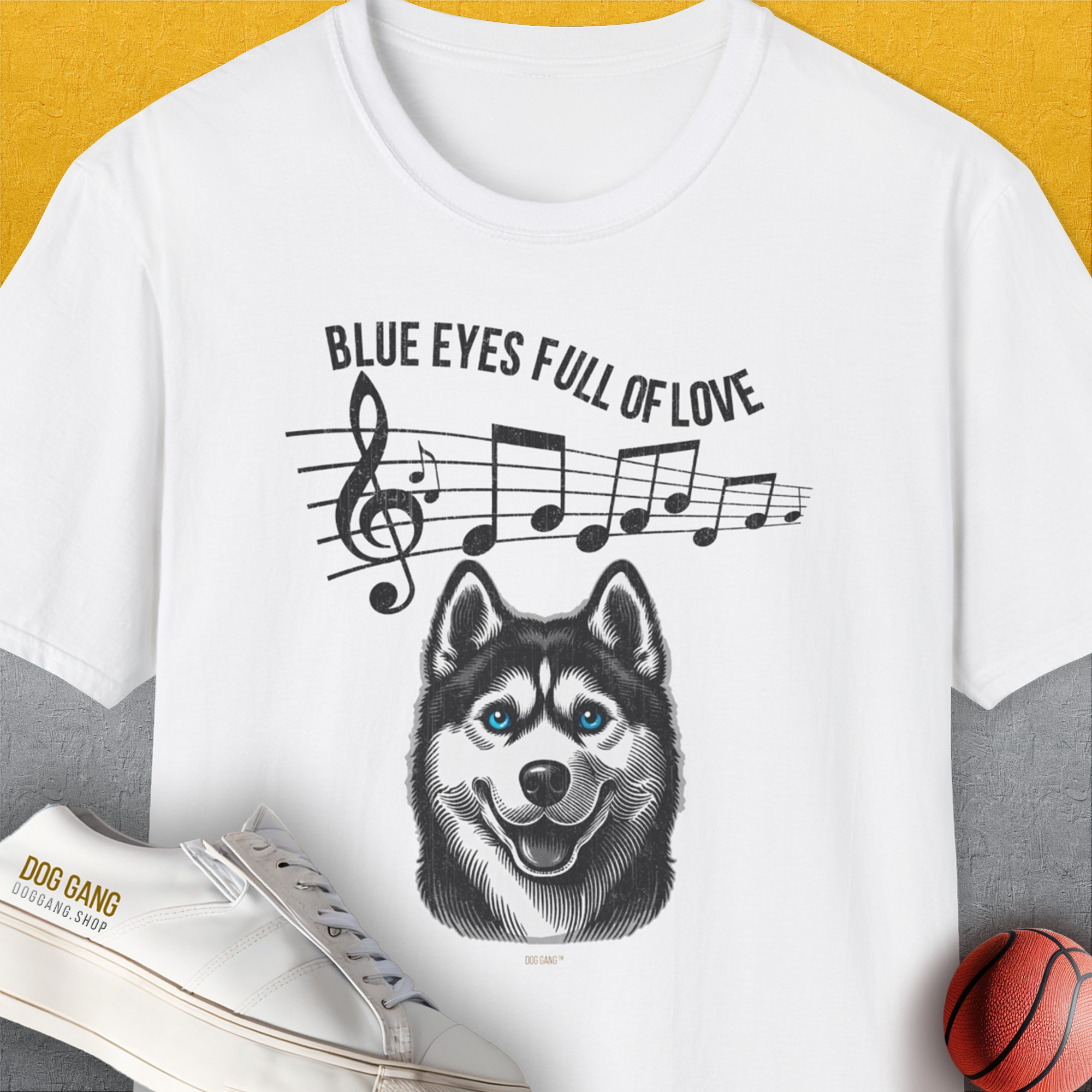 The Blue Eyes Full Of Love, Volume 1 (Husky) shirt showcases a playful husky with music notes and a basketball—perfect for any dog lover. Designed by Dog Gang.