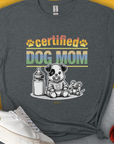 Gray unisex T-shirt featuring a cute puppy with a milk bottle and toy. Perfect dog-themed design for any dog lover. Designed by Dog Gang.