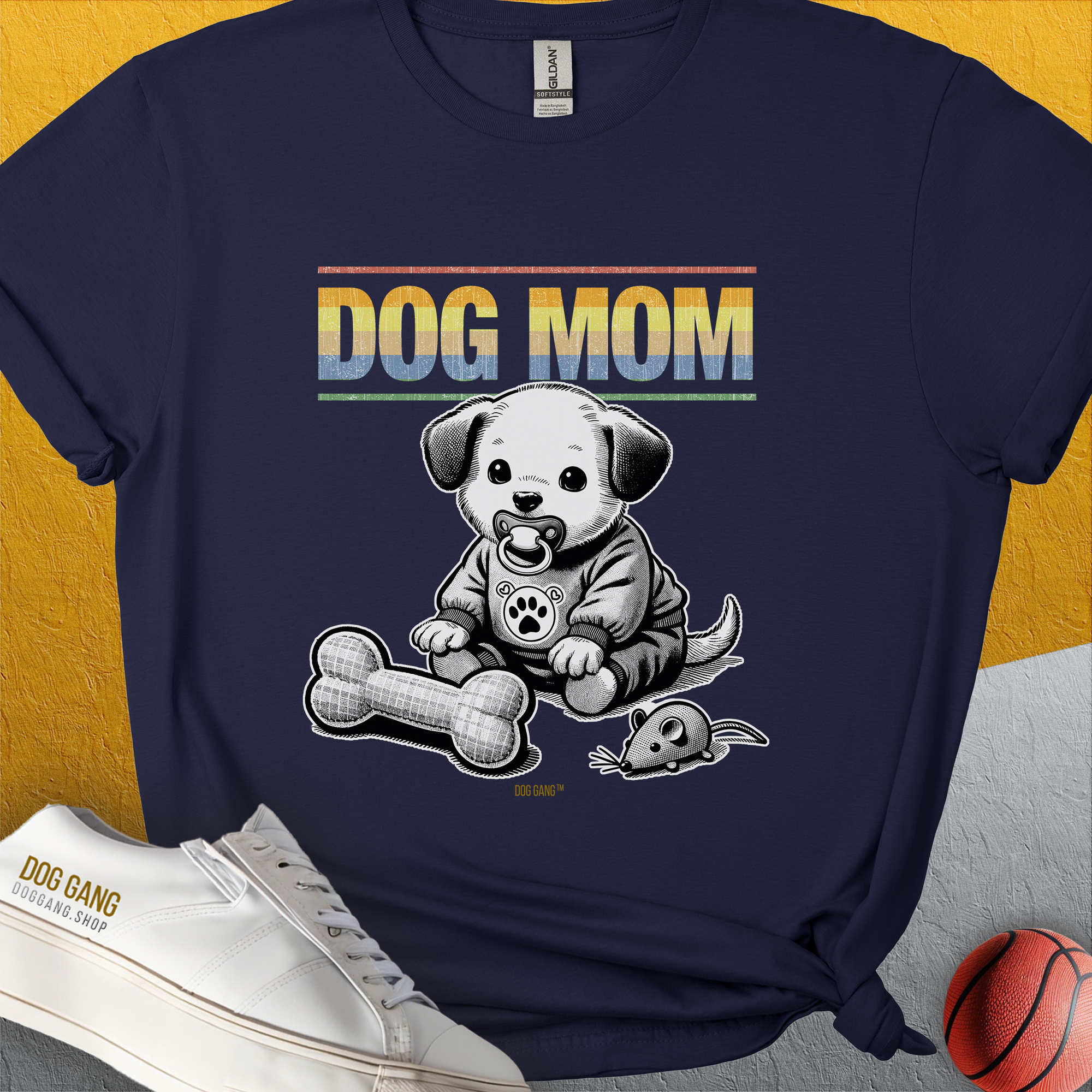 Designed by Dog Gang, this dog lover gift unisex t-shirt in navy features a DOG MOM design with a cute puppy, toy bone, and toy mouse. Ideal for any casual outing.