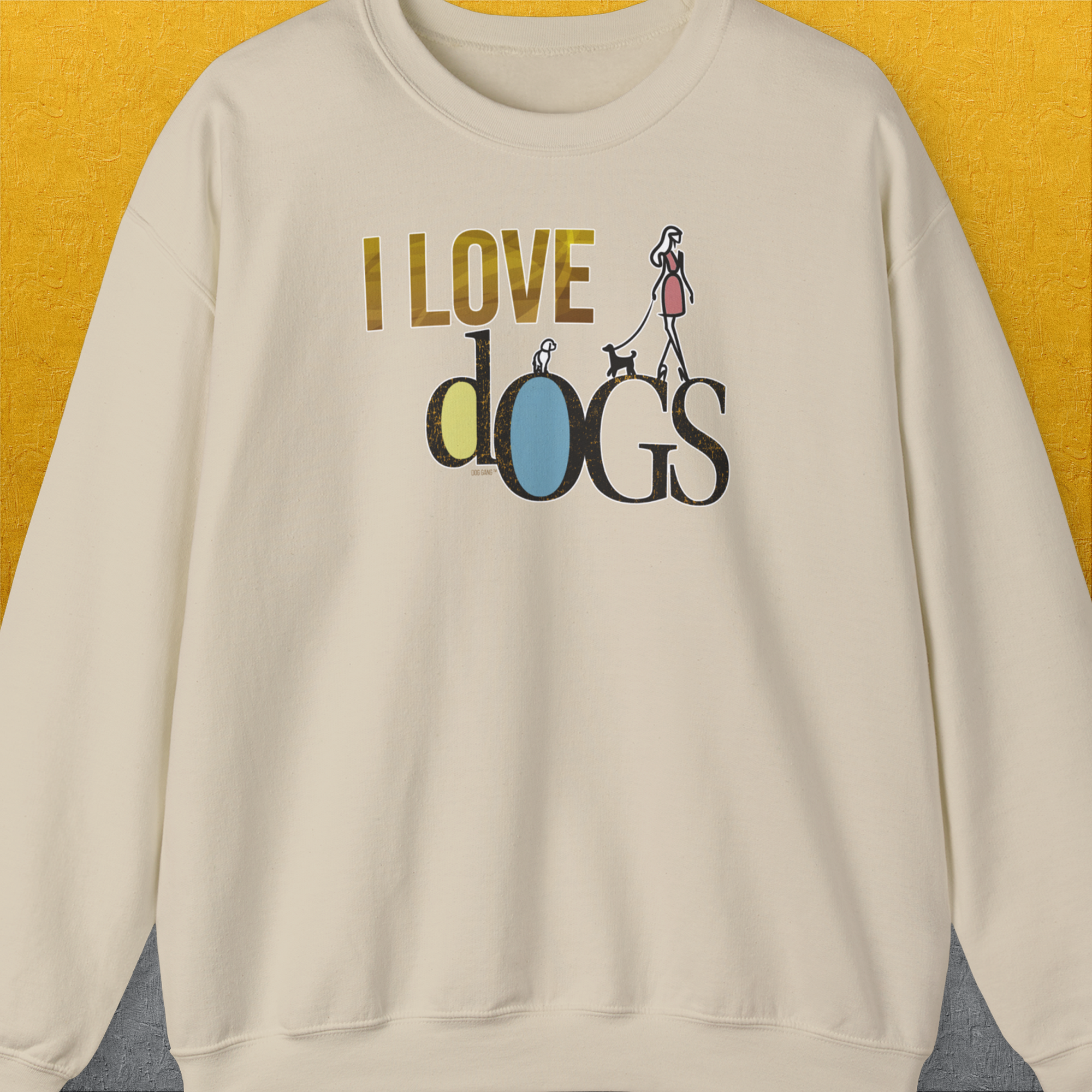 Sand-colored unisex sweatshirt with I LOVE dOGS and a graphic of a woman walking dogs. Made from ethically grown US cotton. Designed by Dog Gang.