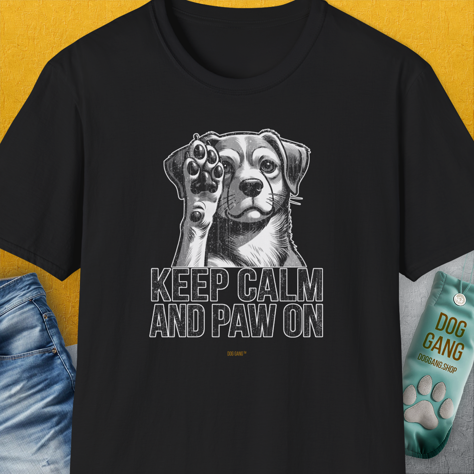 The black t-shirt features a cute dog design with the phrase KEEP CALM AND PAW ON. Perfect for any proud dog owner. Designed by Dog Gang.