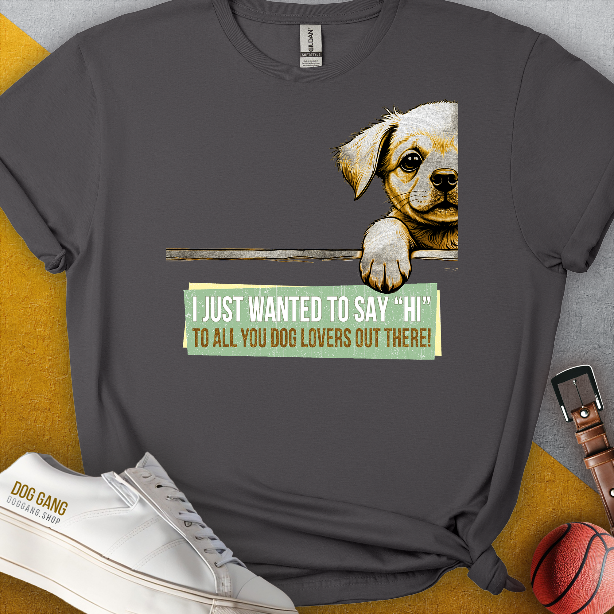 Das Unisex-T-Shirt der Serie „Say Hi“, Band 2, zeigt eine süße Welpengrafik mit dem englischen Satz: „Ich wollte nur ‚Hallo‘ zu allen Hundeliebhabern da draußen sagen!“ Aus 100 % Baumwolle. Design von Dog Gang.