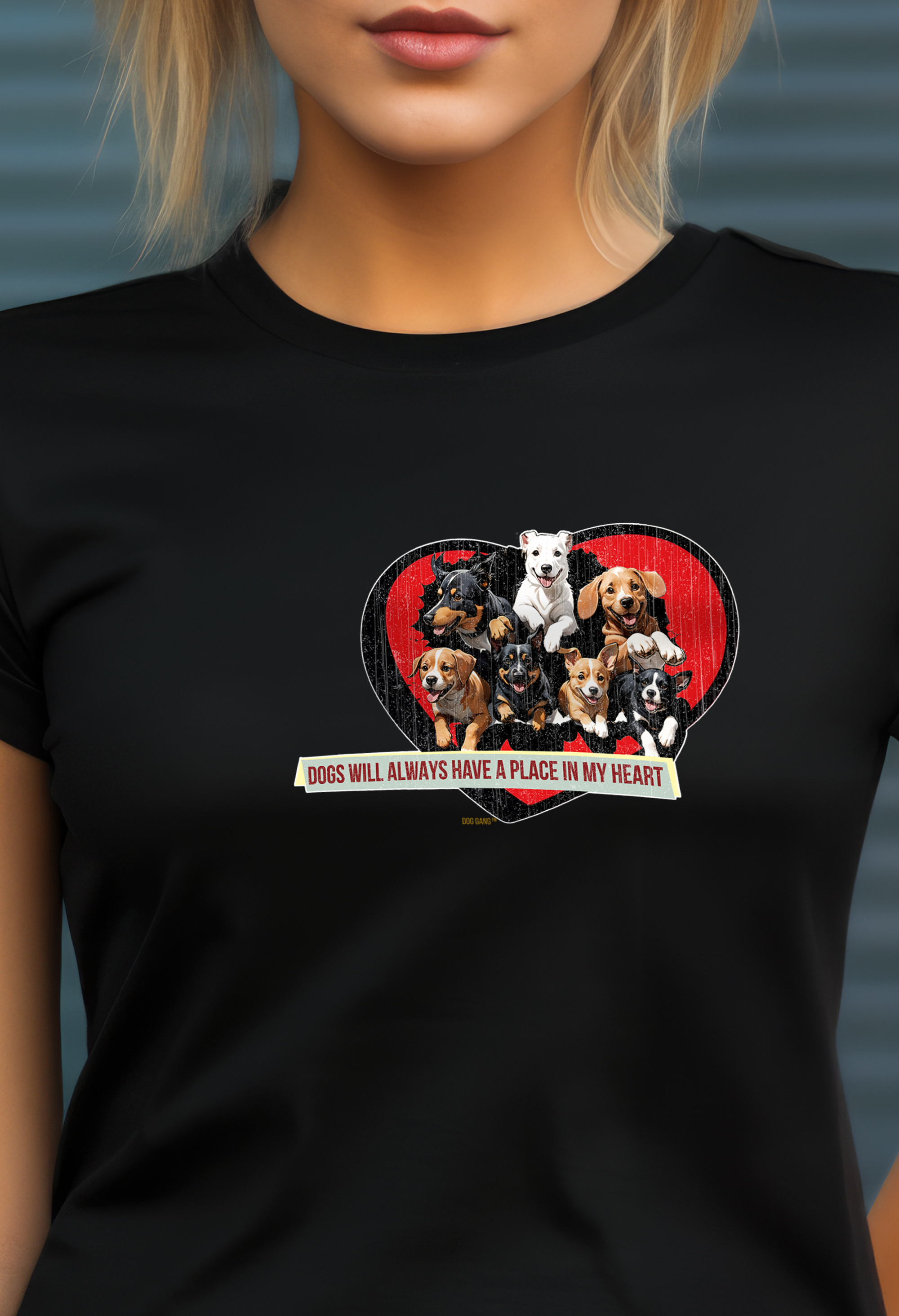 A person is wearing a black t-shirt featuring a graphic of various dogs sitting together inside a red heart shape. Below the graphic, a banner reads, Dogs will always have a place in my heart.