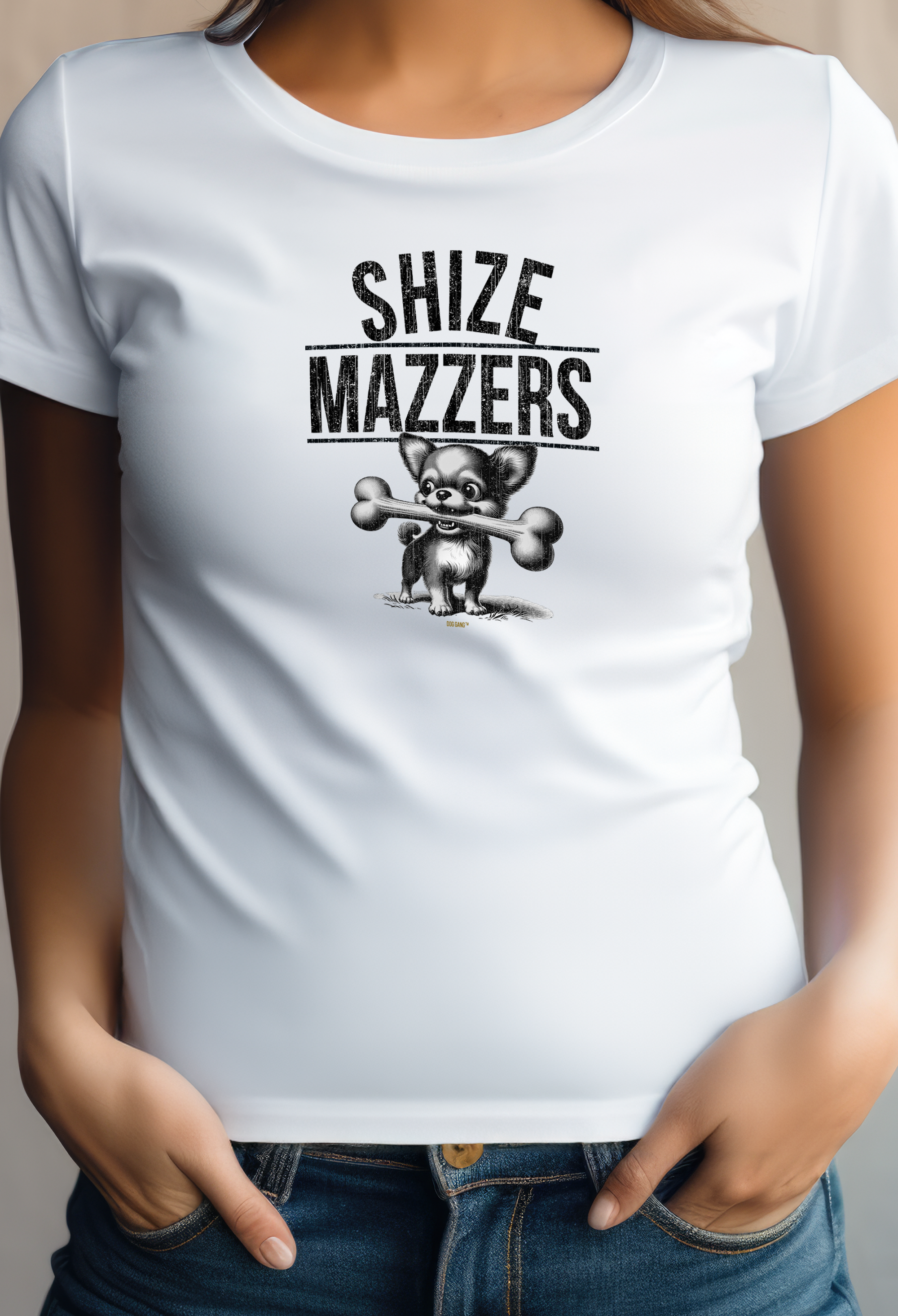 A young woman wears a white women's T-shirt with an image of a cartoon-like Chihuahua carrying an oversized bone in its mouth. The text above the image reads "SHIZE MAZZERS." From the series of the same name by the designer label Dog Gang.