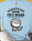 Dieses hellblaue Unisex-T-Shirt zeigt einen niedlichen Hunde-Cartoon mit dem Text „This Beautiful Shirt  Contains Finest Dog Hair Of Exclusive Qualityt.“ Aus weichem Stoff. Design von Dog Gang.