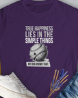 True Happiness Series One, Volume 1 womens T-shirt in purple showcases a baseball design with the quote True happiness lies in the simple things. My dog knows that. Perfect for any dog lover. Designed by Dog Gang.