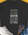 The shirt showcases a funny dog design with the quote: WALKING THE DOG HELPS ME CLEAR MY MIND. Designed by Dog Gang. Crafted from 100% ringspun cotton for comfort and style.