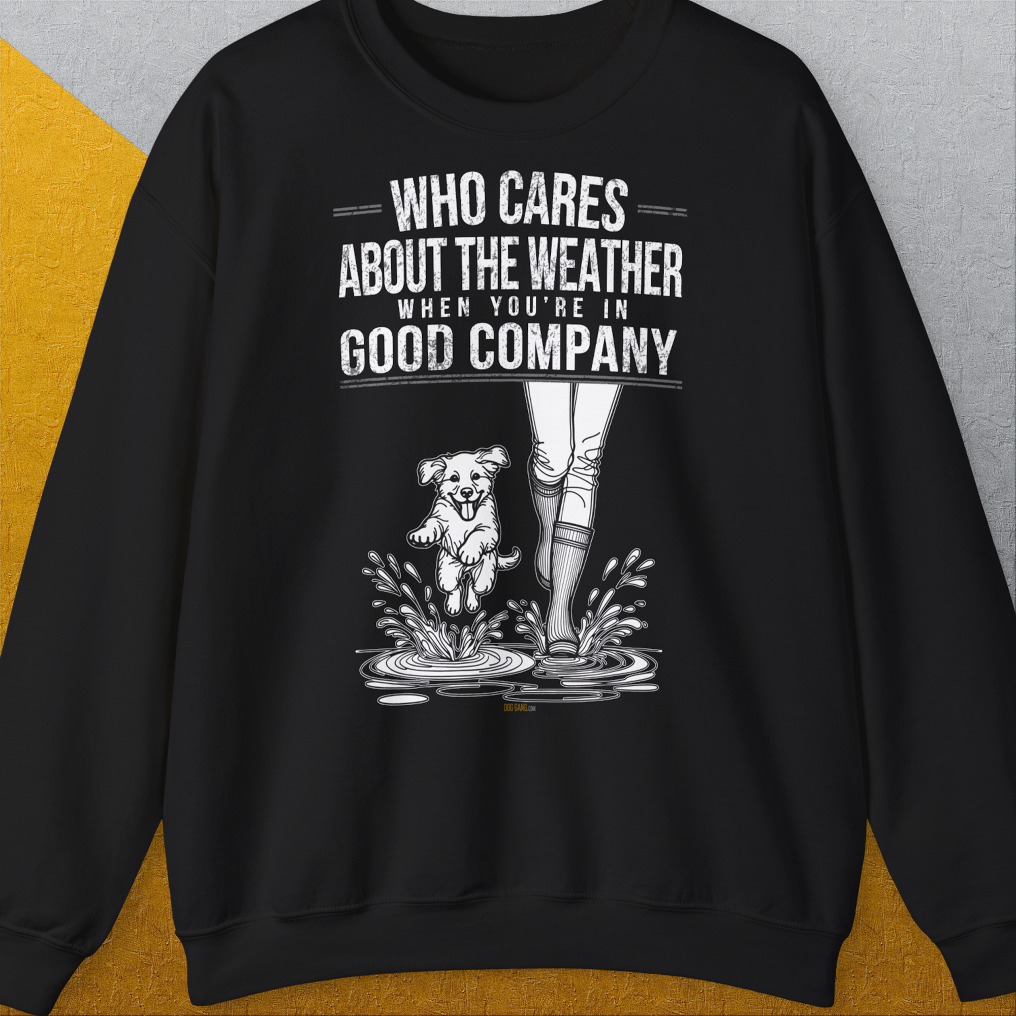 Das Unisex-Sweatshirt „Who Cares About The Weather When You're In Good Company?, zeigt die Beine einer Person in Regenstiefel neben einer süssen Hundegrafik. Entworfen von Dog Gang.